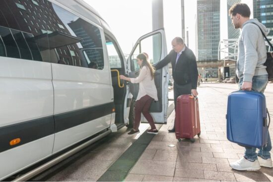 três pessoas carregando malas de viagem usando o serviço de shuttle