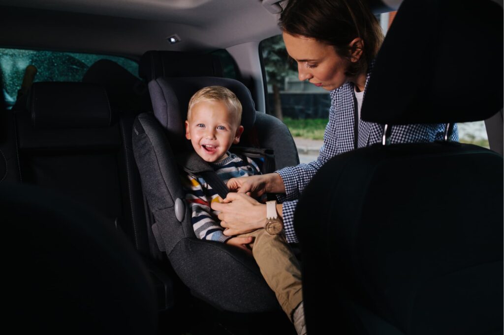 criança em cadeirinha de elevação no carro
