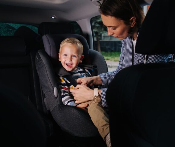 criança em cadeirinha de elevação no carro