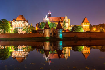 Malbork Castle from across the Nogat river at night. Poland. Europe.