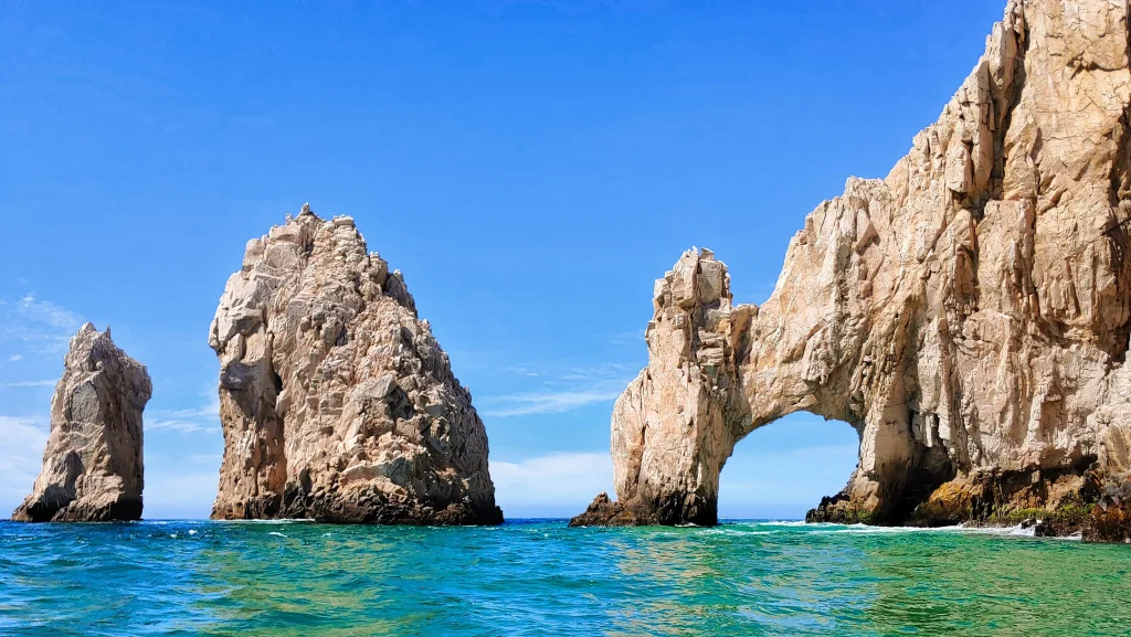 Formación rocosa marrón de Cabo San Lucas, una de las mejores playas de México, en el mar azul bajo un cielo azul durante el día.