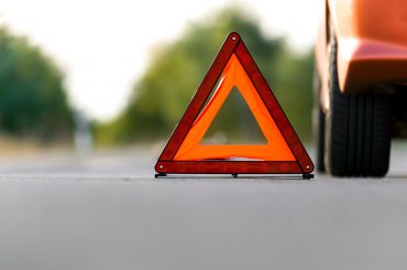 car parked on the side of the road with a red triangle