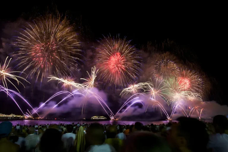 vista da queima de fogos na praia de Copacabana com fogos coloridos, na maioria roxo purpura, vermelho e dourado