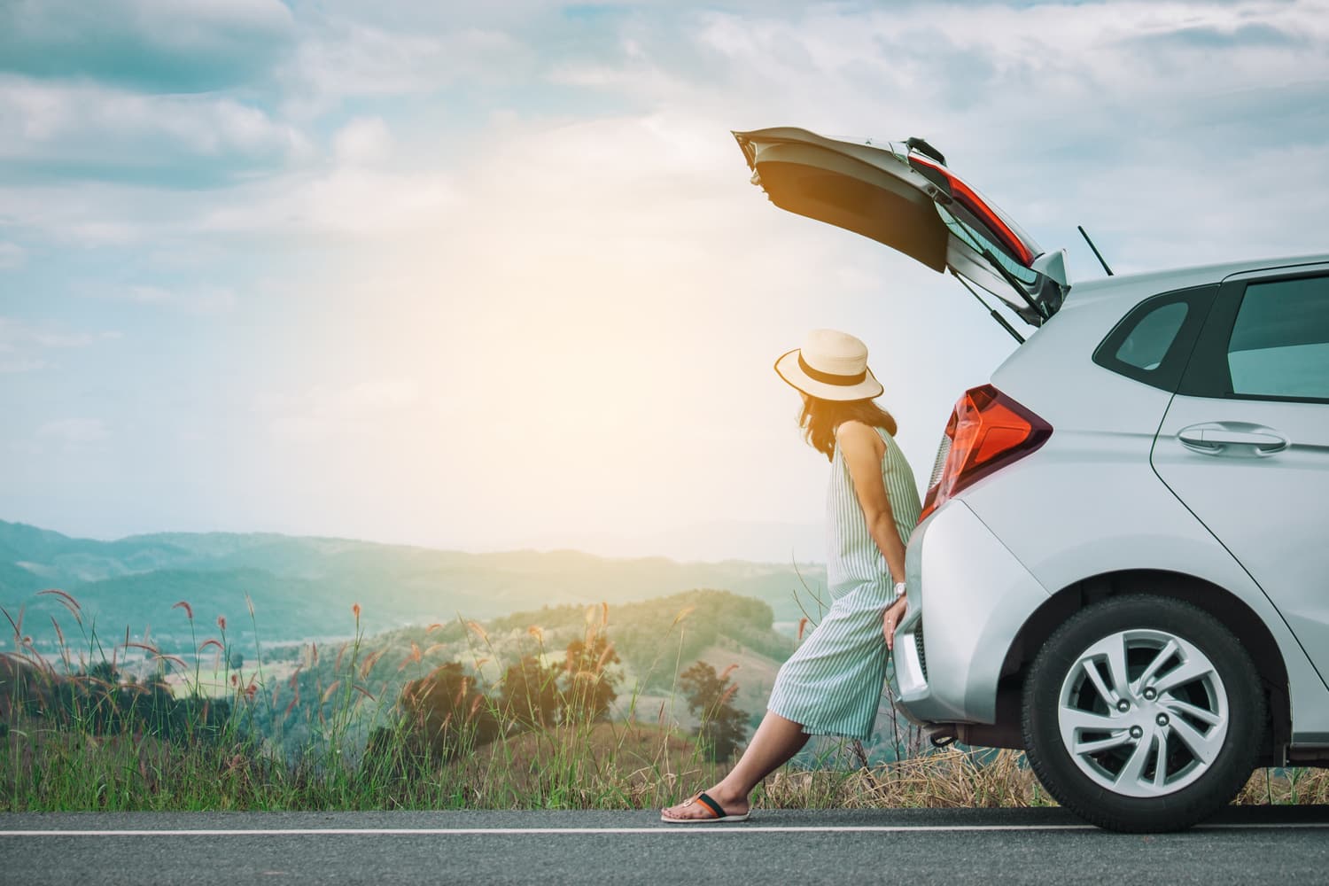woman sitting on the back of a car