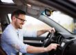 man smiling driving a car