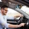 man smiling driving a car