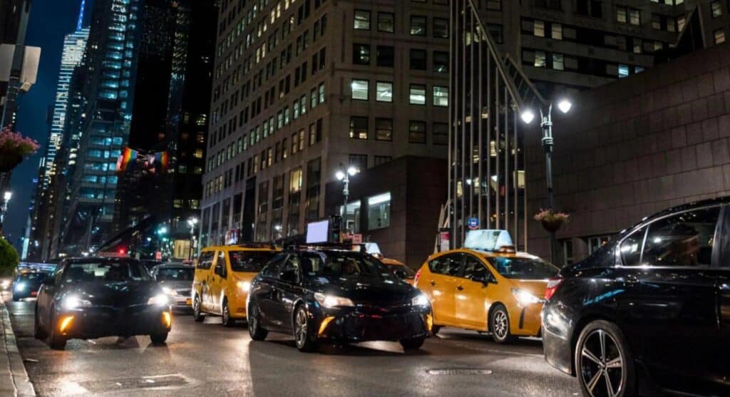 uma rua cheia de carros a noite nos EUA