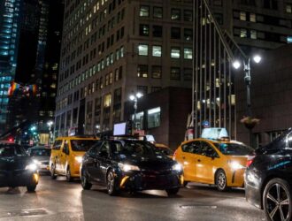 uma rua cheia de carros a noite nos EUA