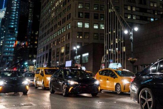 uma rua cheia de carros a noite nos EUA