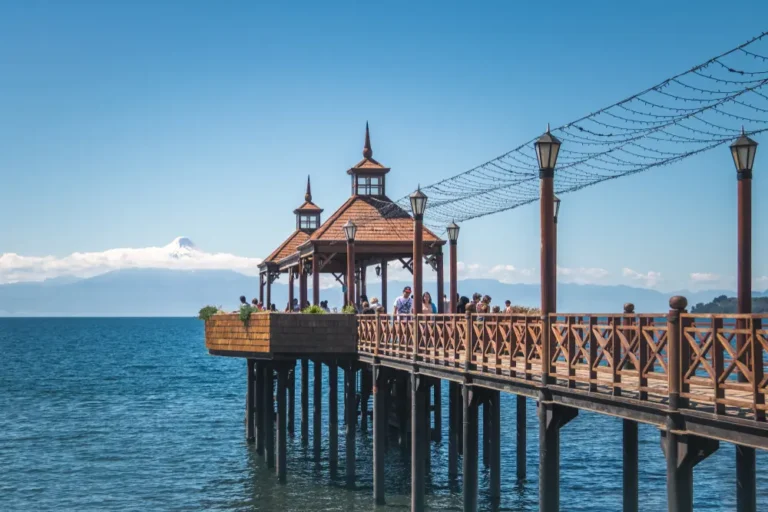 Foto del famoso muelle de Frutillar en un día soleado, con el cielo y el mar azules.