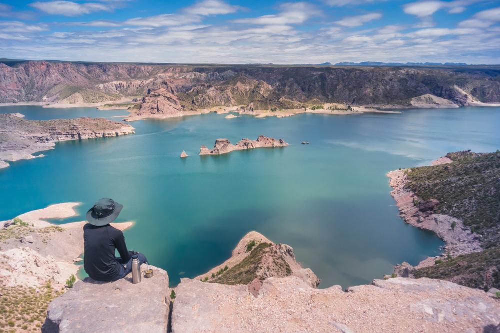 Turista admirando un lago en Mendoza, Argentina