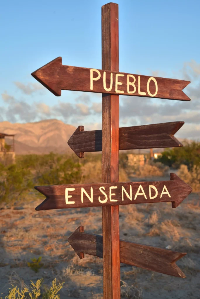 Letrero indicando las ciudades de Pueblo y Ensenada en México