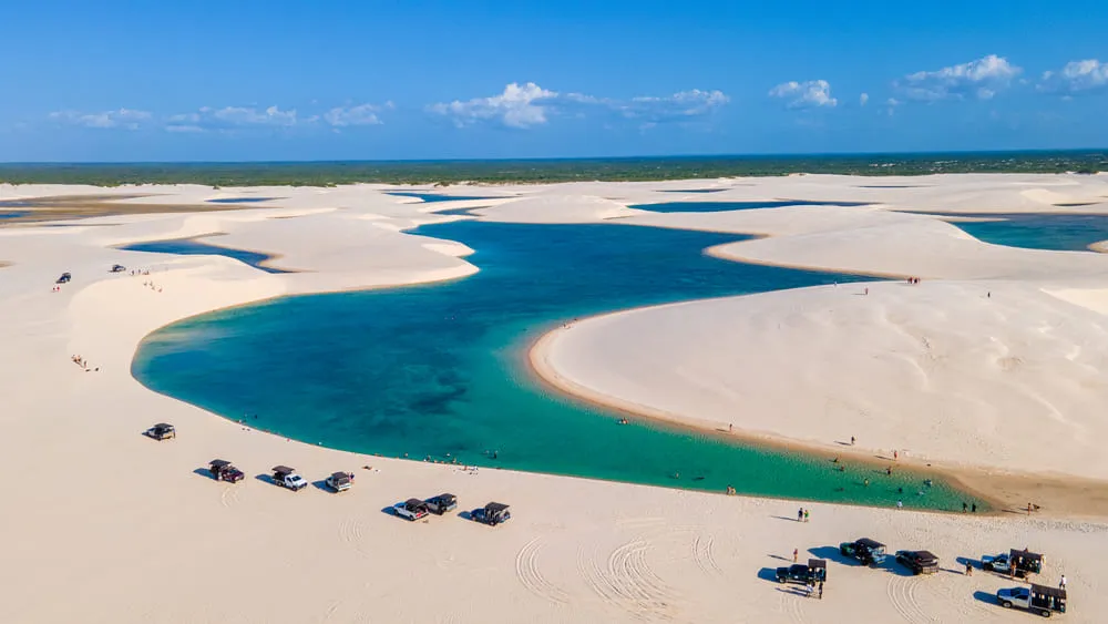 Lençóis Maranhenses com suas lagoas azuis e verdes, muita areia e céu azul.