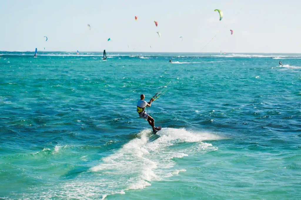 Persona practicando kitesurf en un mar azul turquesa