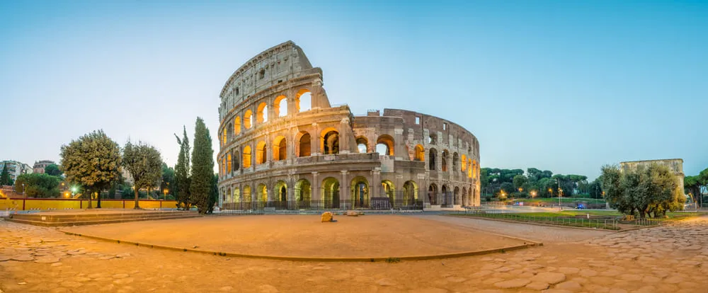 Foto do Coliseu, em Roma, na Itália, e o céu azul ao fundo.