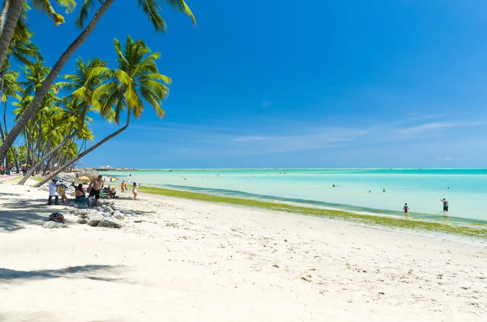 Foto da Praia de Maragogi, no Alagoas. O céu está completamente azul e a água cristalina.