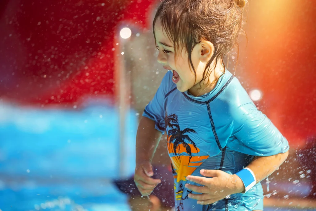 Foto de criança feliz brincando na água dentro de uma piscina no Parque Aquático de Foz do Iguaçu.