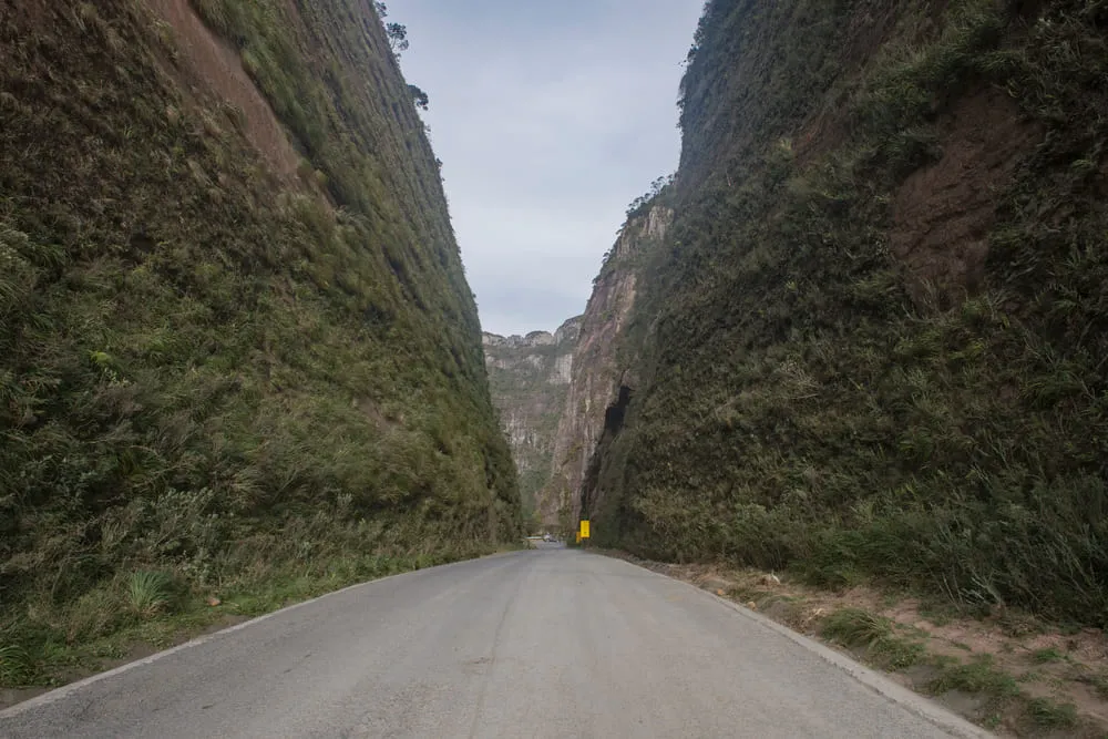 Foto aérea de Urubici na Serra Catarinense. É possível ver a famosa formação rochosa que forma dois paredões ao redor da estrada, no centro. É uma paisagem impressionante.
