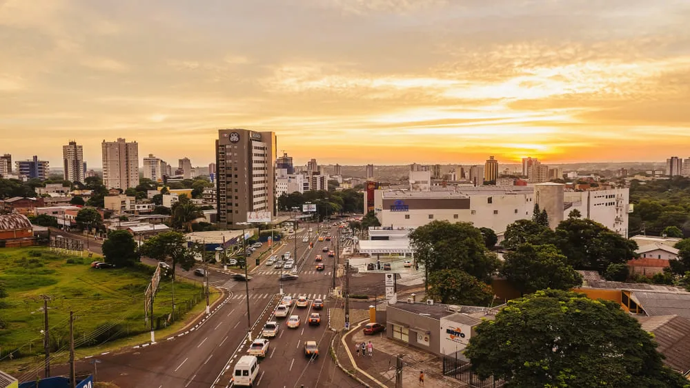 Foto urbana da cidade de Foz do Iguaçu, com seus prédios comerciais, residências e carros na rua.