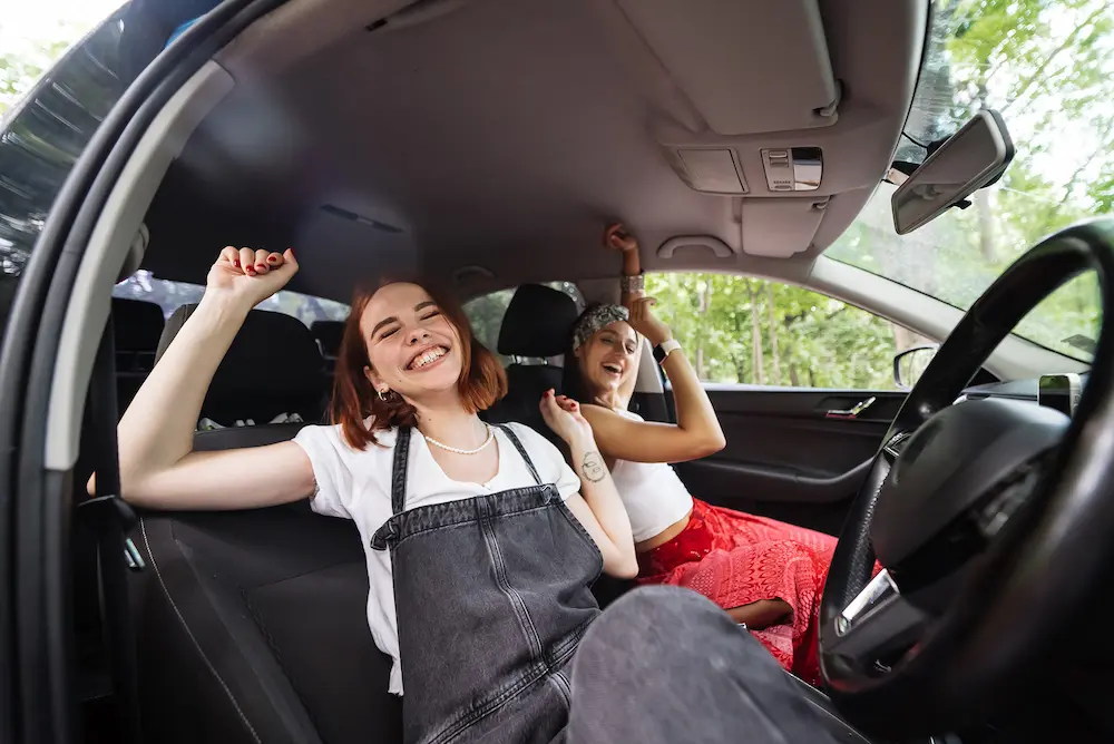 duas garotas em um carro ouvindo musicas para viajar