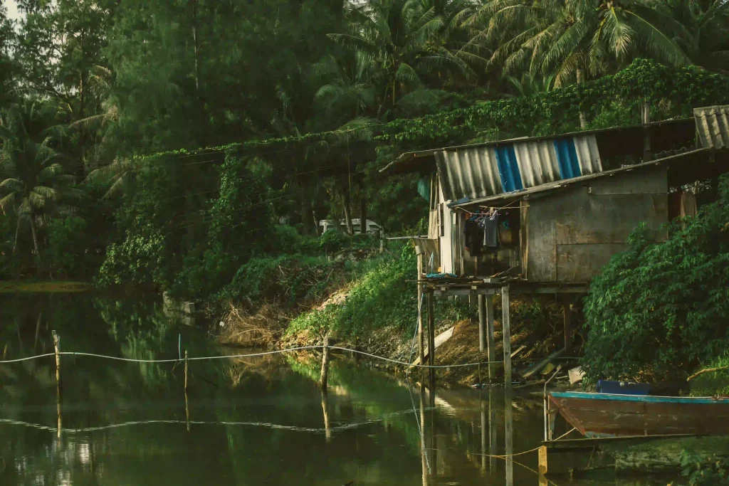 Casa en un rio tailandés con una embarcación al lado