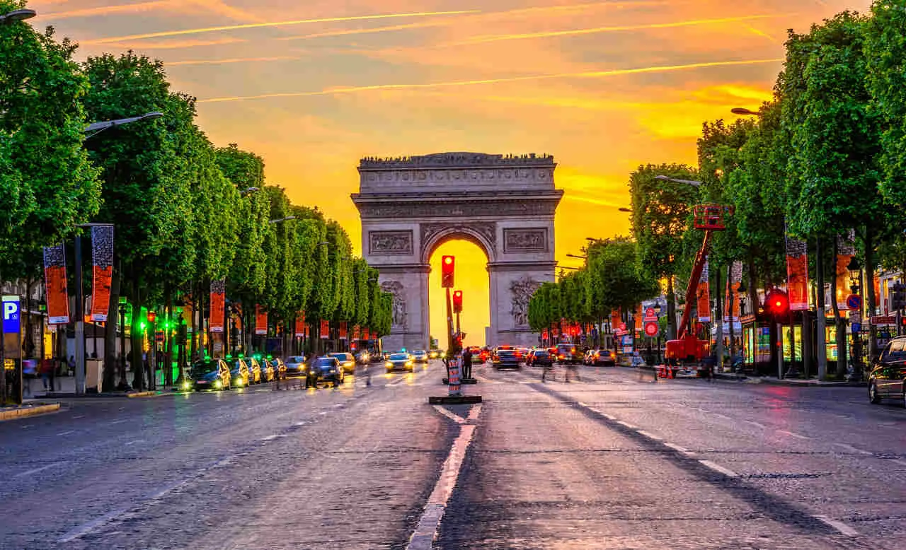 As warmth bathes the iconic Arc de Triomphe in hues of amber and gold, the last rays of the day cast a gentle glow on the intricate carvings. A testament to Parisian grandeur, the silhouette stands proud against the vivid canvas of a sunset sky, whispering tales of history and elegance