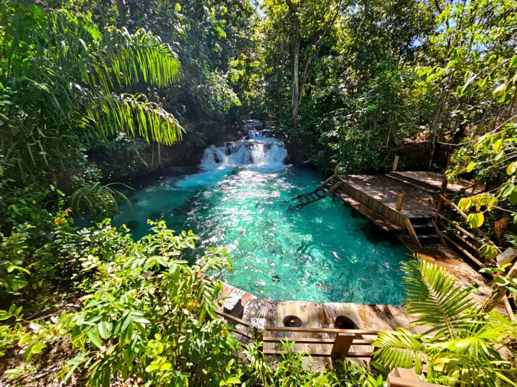 Foto de uma das cachoeiras mais famosas do Jalapão, Tocantins. A água é super cristalina e a vegetação verde fica ao redor, dando um super contraste. A cachoeira fica ao fundo.