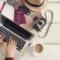 Foto de computador, pasaporte, diario y otras cosas necesarias para aprender cómo hacer un itinerario de viaje.