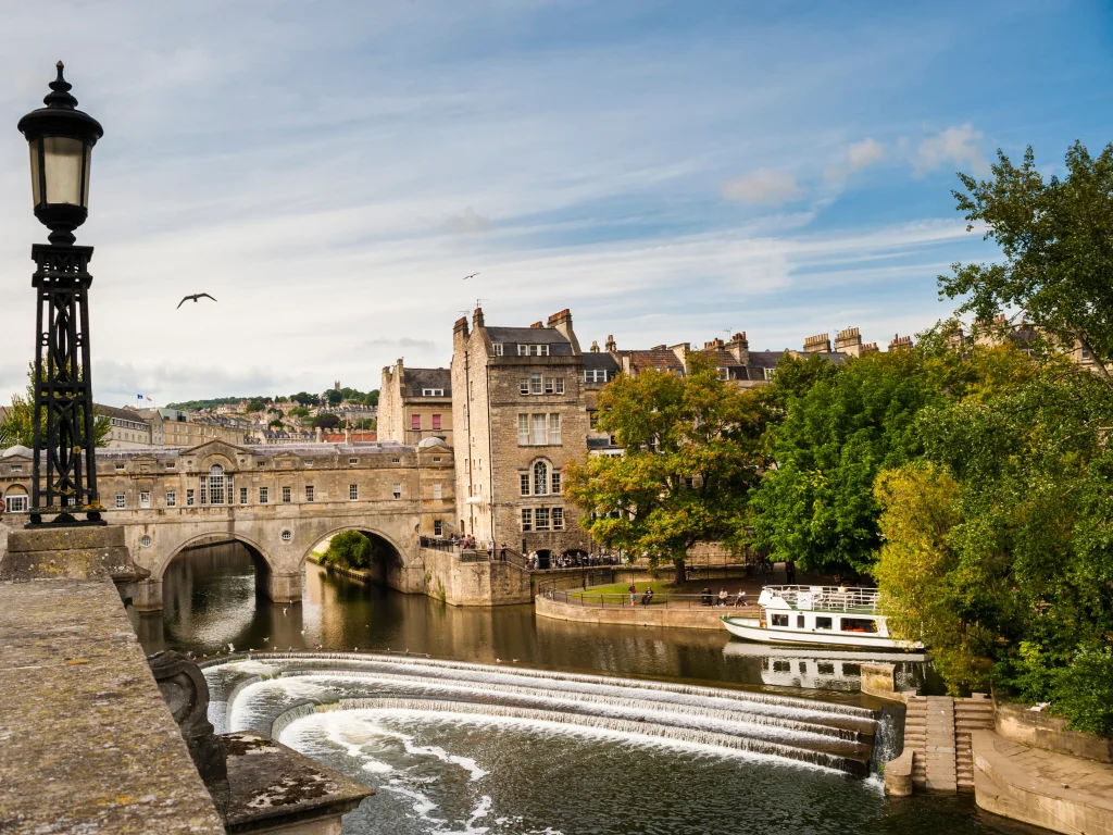 A panoramic view of the iconic Pulteney Bridge in Bath, England, spanning the River Avon.