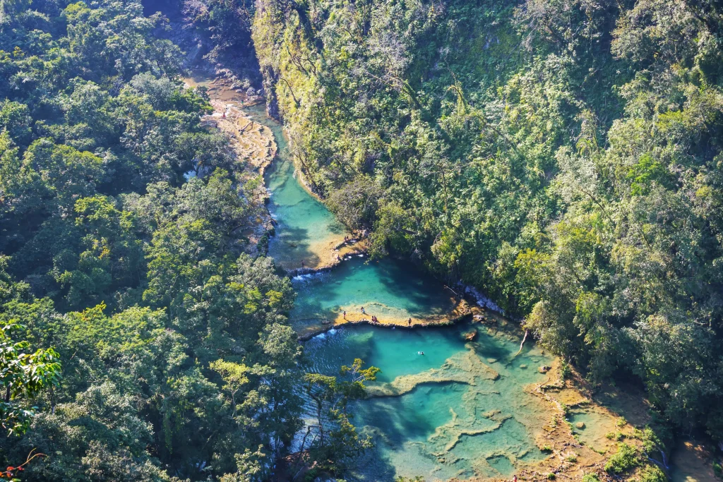 Foto das piscinas naturais da Guatemala. A cor da água é bem azul e cristalina, com vegetação em volta.