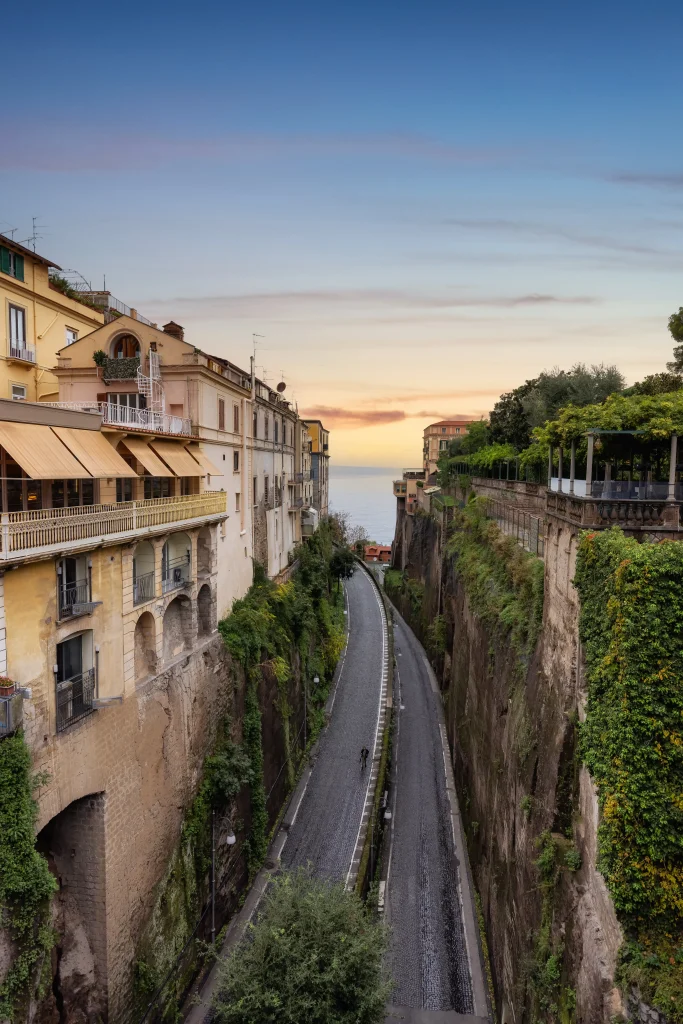 Narrow streets of Sorrento lined with buildings at dusk.