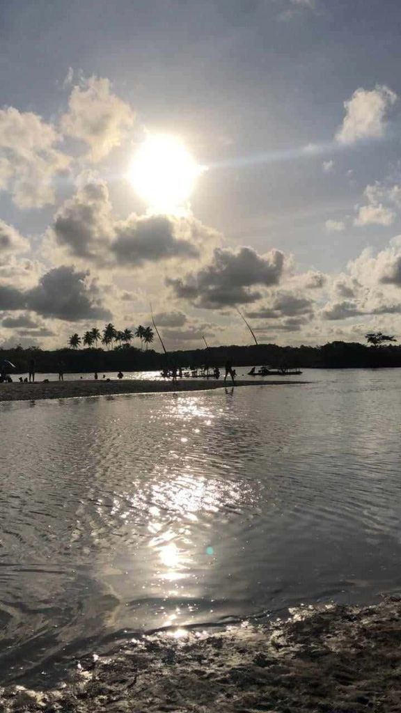 Foto do Pontal de Maracaipe onde é possível ver o sol escaldante e o rio refletindo a luz do sol. Não há pessoas na foto.