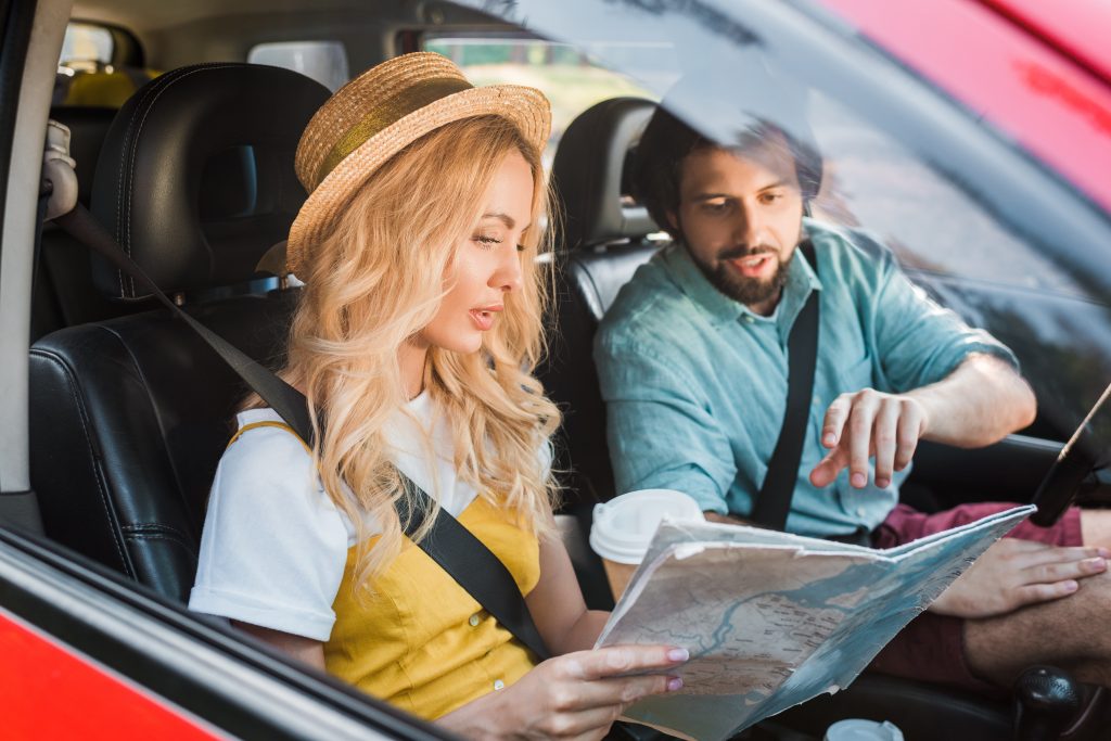 couple sitting in car and looking at map