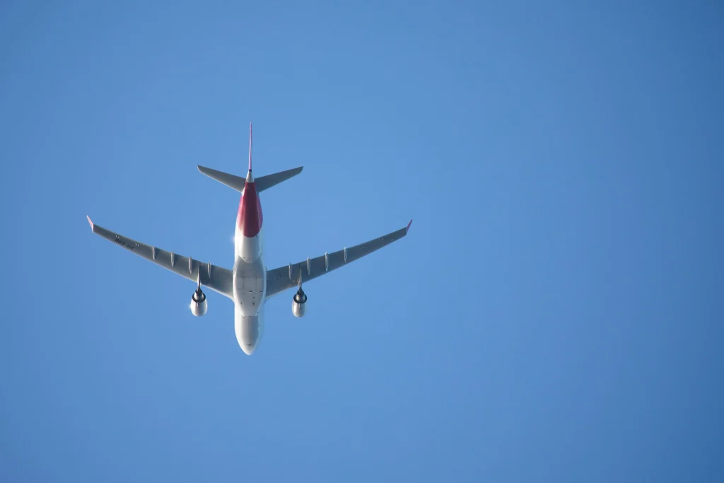 Um avião branco voando no céu azul.