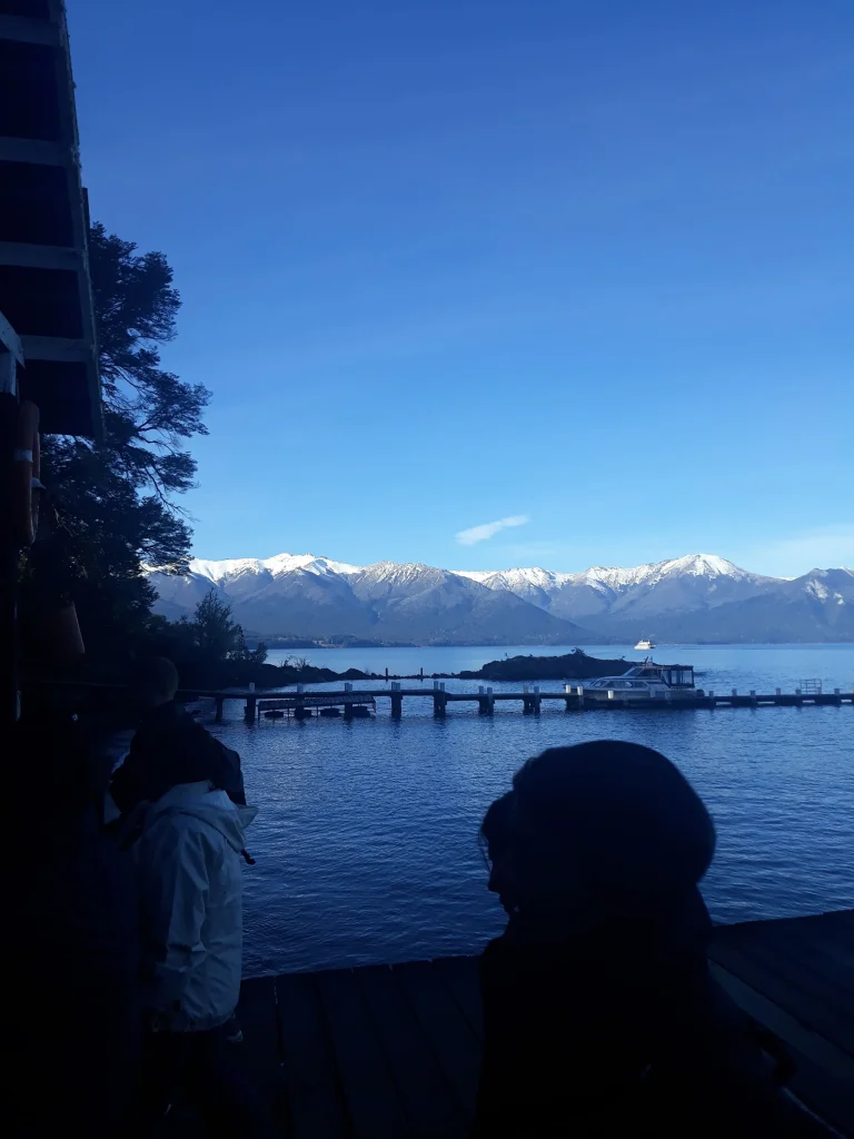 Uma paisagem com céu azul e montanhas ao fundo com gelo no topo em Bariloche na Argentina.