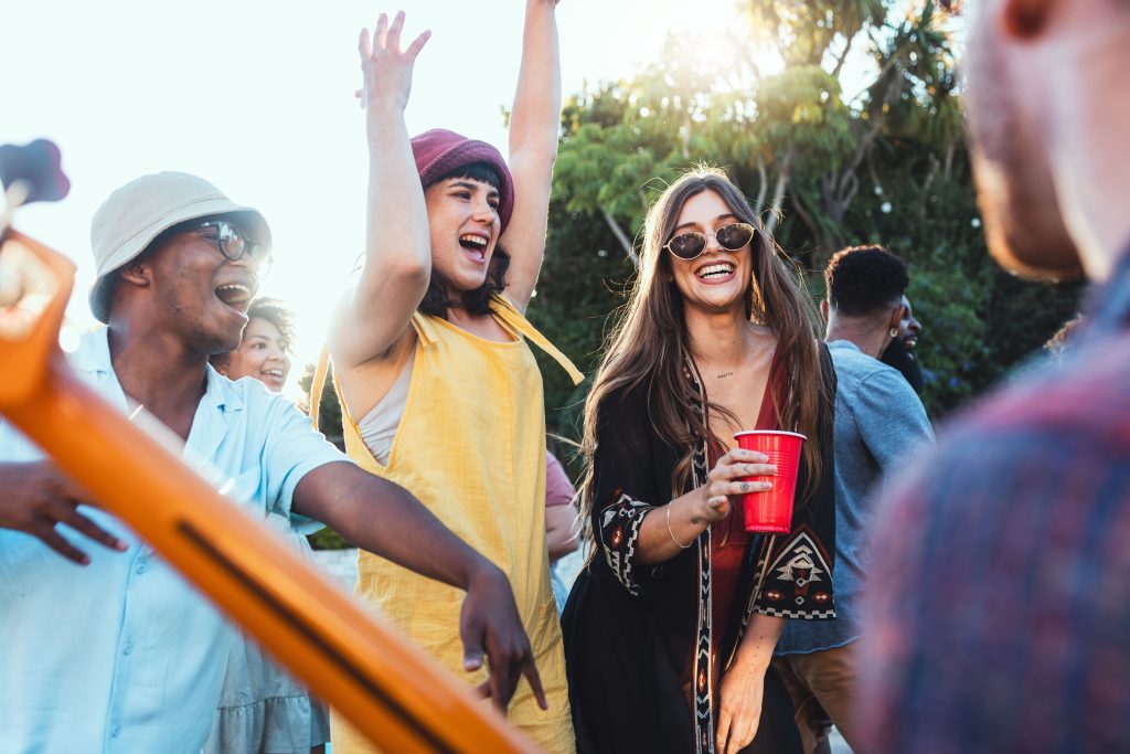 Pessoas sorrindo e cantando em um festival de música