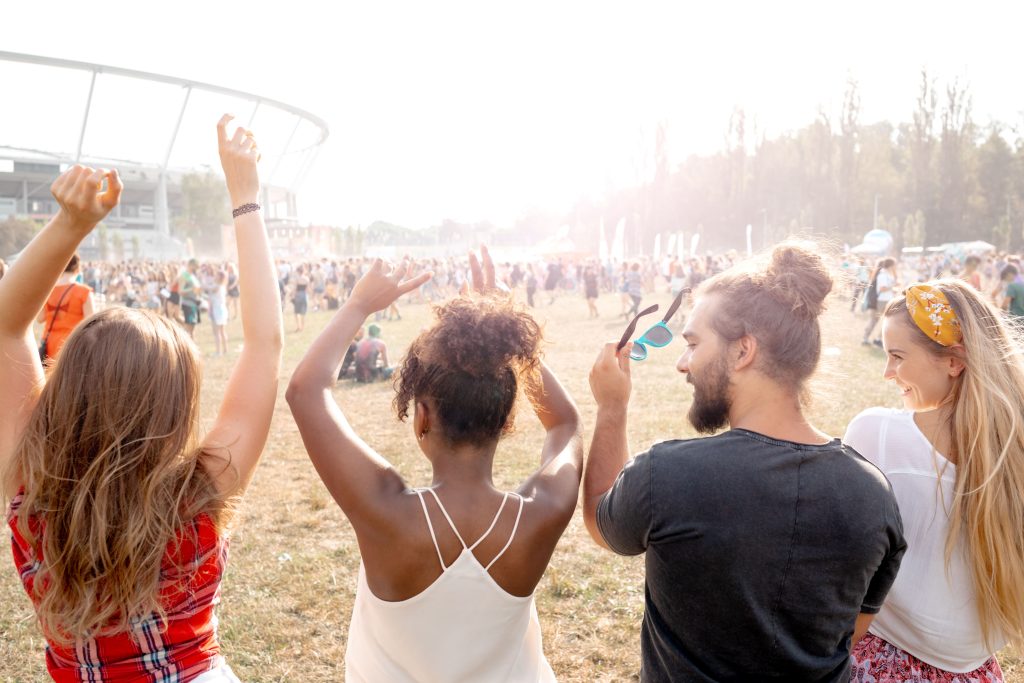 Vários jovens dançando e se divertindo em um festival de música.