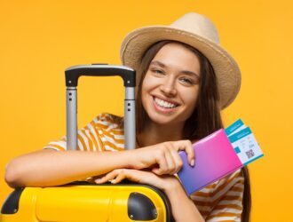 Jovem viajante estudante feliz segurando passaporte com passagens aéreas e mala