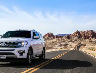 suv branca em um dia ensolarado em uma estrada com deserto ao lado
