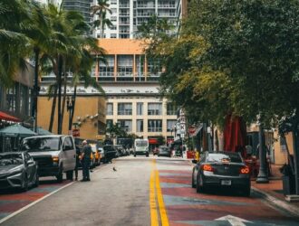 rua arborizada em miami beach, com carros e pessoas