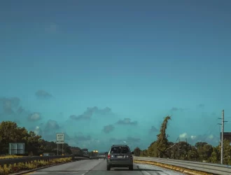 um carro em uma estrada ampla nos USA com céu azul aberto