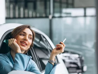 mulher sentada no carro segurando a chave com a cabeça para fora do vidro