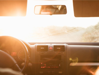 vista de dentro do carro para o para-brisa com sol batendo no vidro