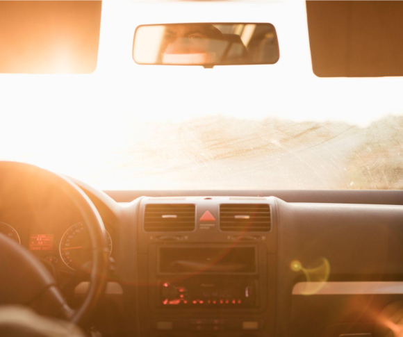 vista de dentro do carro para o para-brisa com sol batendo no vidro