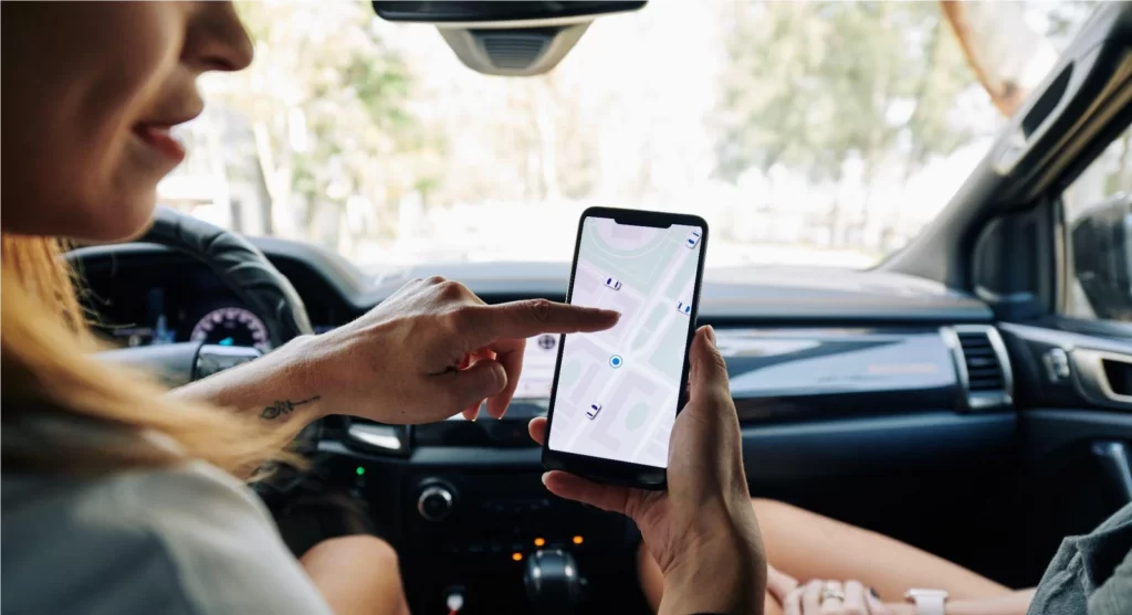 Mulher olhando um mapa em seu telefone celular dentro do carro