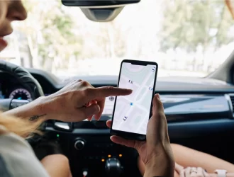 Mulher olhando um mapa em seu telefone celular dentro do carro