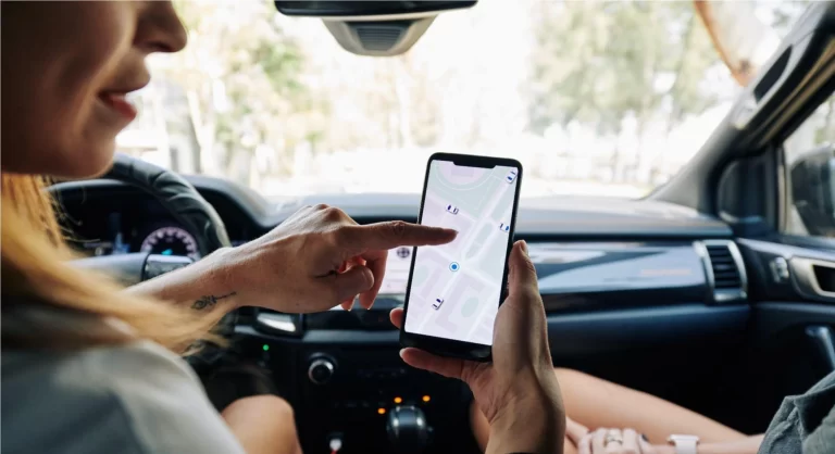 Mulher olhando um mapa em seu telefone celular dentro do carro
