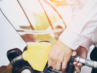 Homem colocando gasolina em seu carro em um posto de gasolina