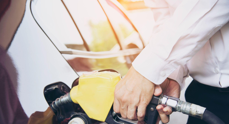 Homem colocando gasolina em seu carro em um posto de gasolina