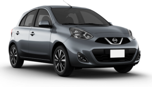 Nissan em fundo preto: vista frontal de um carro compacto prata com faróis acesos, grade em formato de V e rodas de liga leve, modelo hatch moderno.